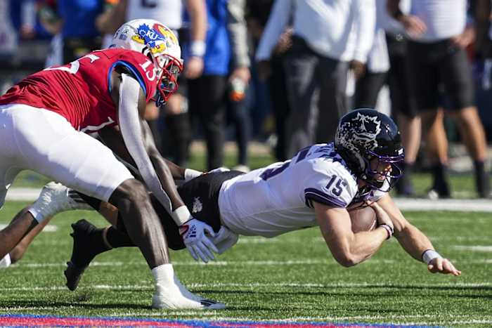 Oct 8, 2022; Lawrence, Kansas, USA; TCU Horned Frogs quarterback Max Duggan (15) dives forward against Kansas Jayhawks linebacker Craig Young (15) during the first half at David Booth Kansas Memorial Stadium.